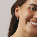 gold hoop earrings with heart cut 0.57ct diamond pendants.