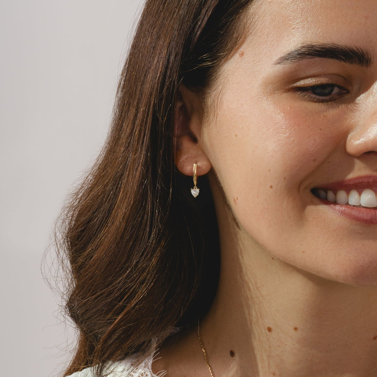 gold hoop earrings with heart cut 0.57ct diamond pendants.