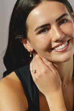 gold hoop earrings with oval-cut 0.84ct diamonds in a bezel setting.
