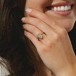 A yellow gold ring featuring a marquise cut diamond center stone in a bezel setting.