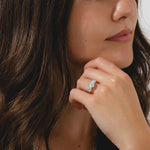 A yellow gold three-stone ring featuring a round cut center diamond flanked by two side diamonds.