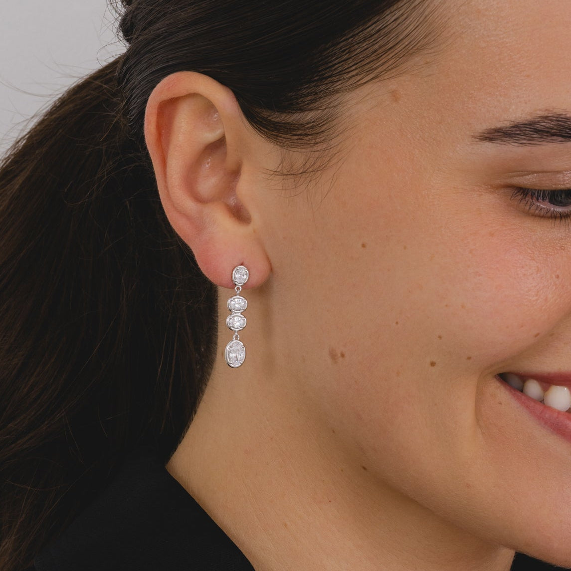 A pair of silver drop earrings with four cascading oval cut cubic zirconia's.