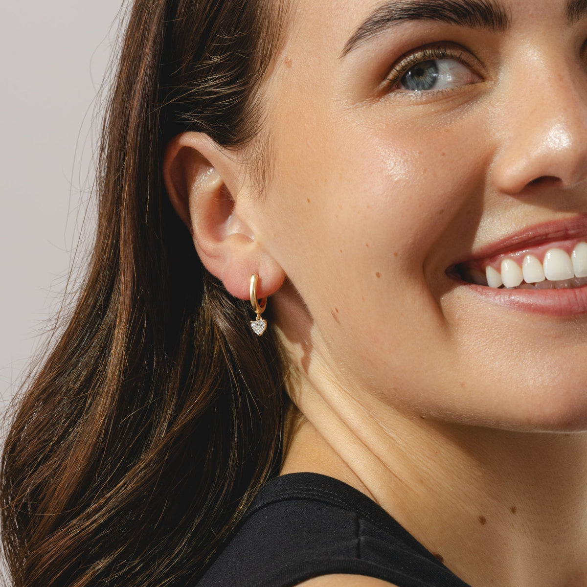 gold hoop earrings with heart cut 0.57ct diamond pendants.