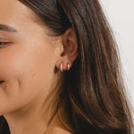 gold huggie hoop earrings with small diamonds set along the front.
