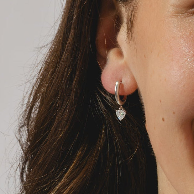 Hoop earrings with heart cut 0.57ct diamond pendants in a platinum bezel setting.